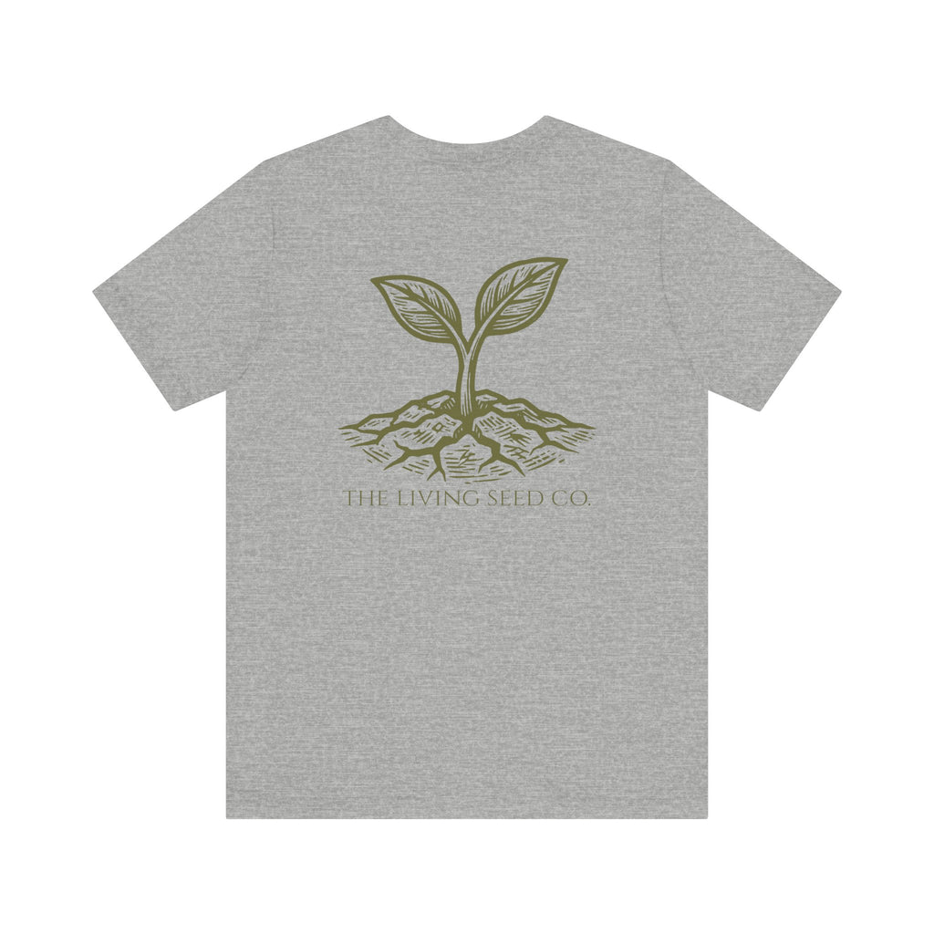 The Original Tee in Athletic Heather — back view flat mockup — grey heather unisex t-shirt featuring The Living Seed Co. etching-style sprouting seed graphic in olive ink with wordmark below. Bella+Canvas 3001.