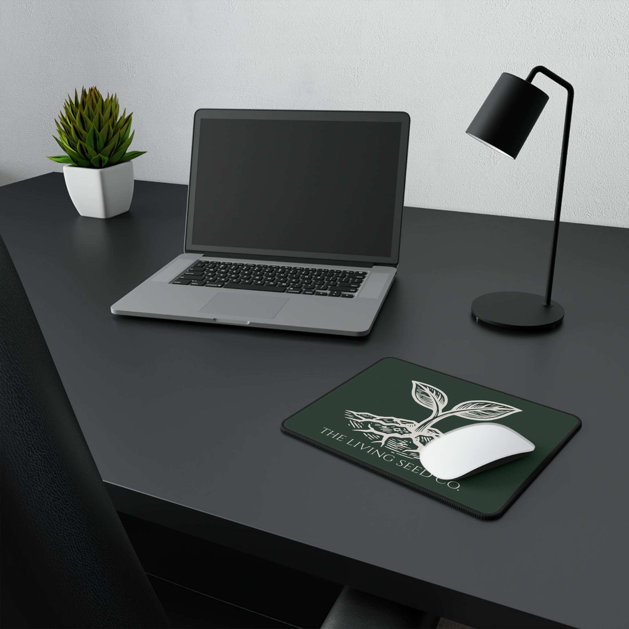 he Original Mouse Pad in Forest Deep — lifestyle shot — mouse pad on a dark desk alongside a laptop and lamp showing the Forest Deep colorway in a workspace setting.