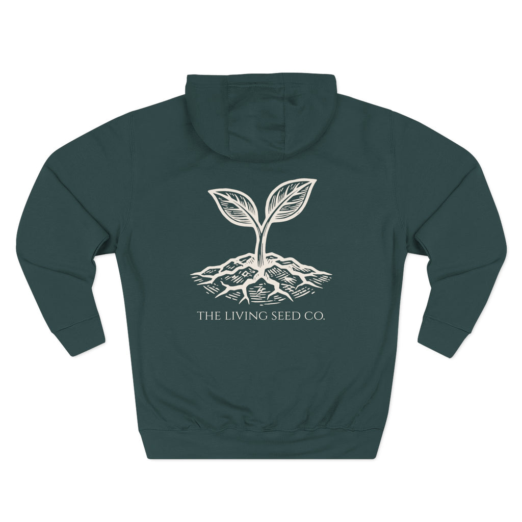 The Original Hoodie (Lane Seven) in Forest — back view flat mockup — forest green pullover hoodie featuring The Living Seed Co. etching-style sprouting seed graphic in parchment ink with wordmark below. Lane Seven LS14001.