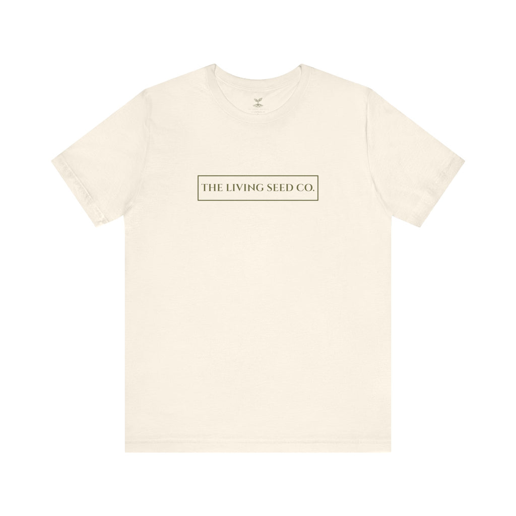 The Original Tee in Natural — front view flat mockup — cream unisex t-shirt featuring The Living Seed Co. boxed wordmark on chest in olive ink. Bella+Canvas 3001.