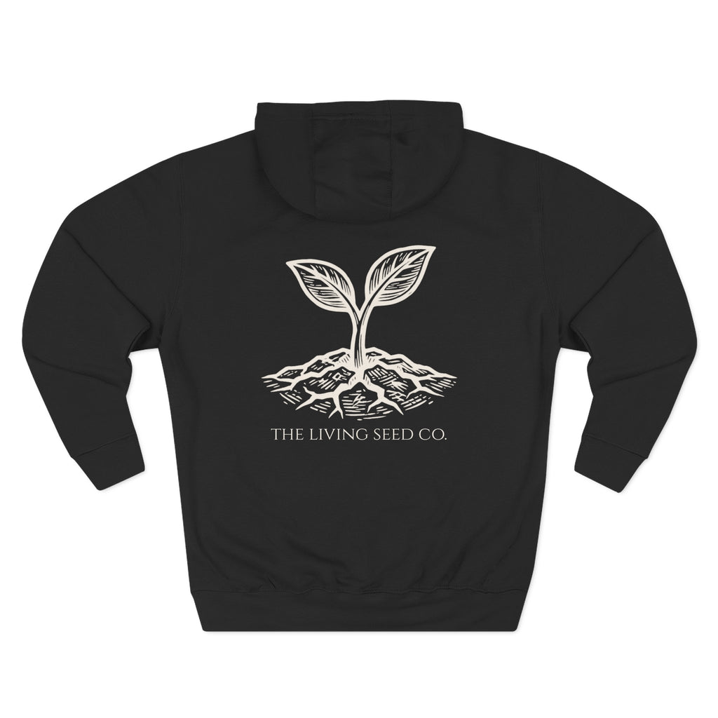 The Original Hoodie (Lane Seven) in Black — back view flat mockup — black pullover hoodie featuring The Living Seed Co. etching-style sprouting seed graphic in parchment ink with wordmark below. Lane Seven LS14001.