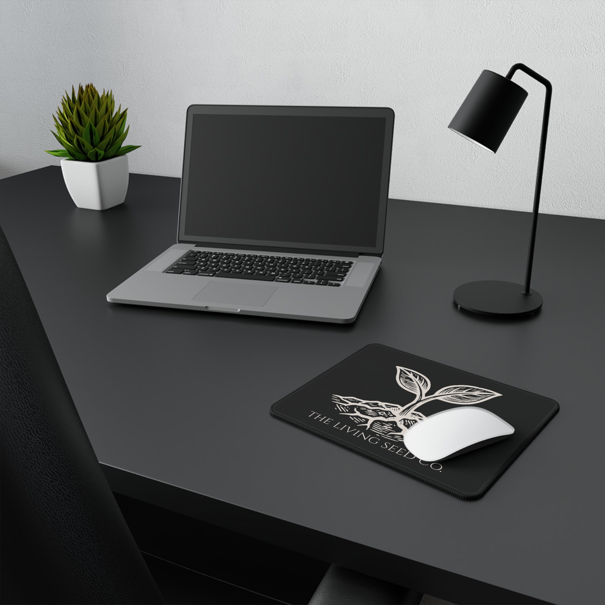 he Original Mouse Pad in Black — lifestyle shot — mouse pad on a dark desk alongside a laptop and lamp showing the Forest Deep colorway in a workspace setting.