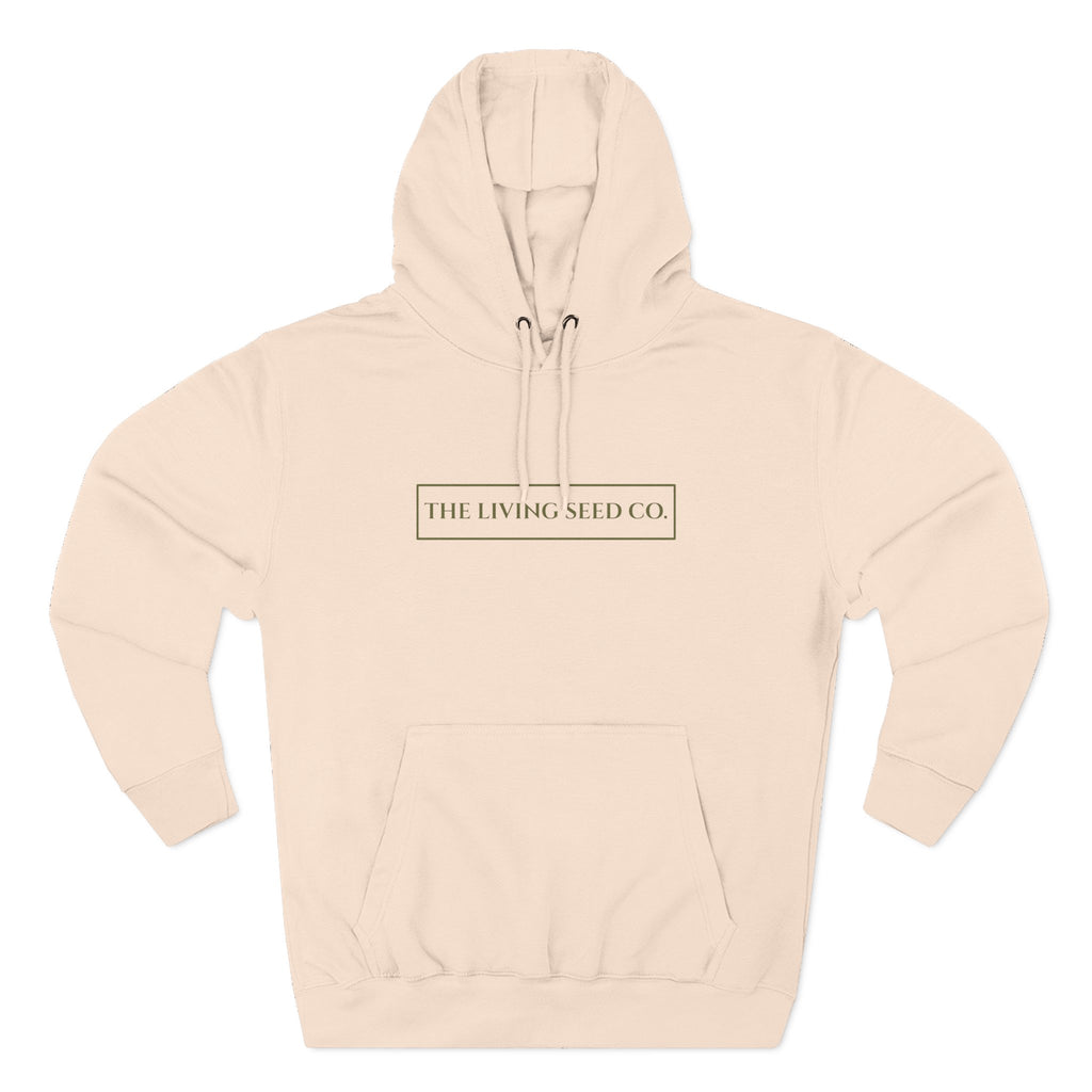 The Original Hoodie (Lane Seven) in Pale Pink — front view flat mockup — pale pink pullover hoodie featuring The Living Seed Co. boxed wordmark on chest in olive ink. Lane Seven LS14001.