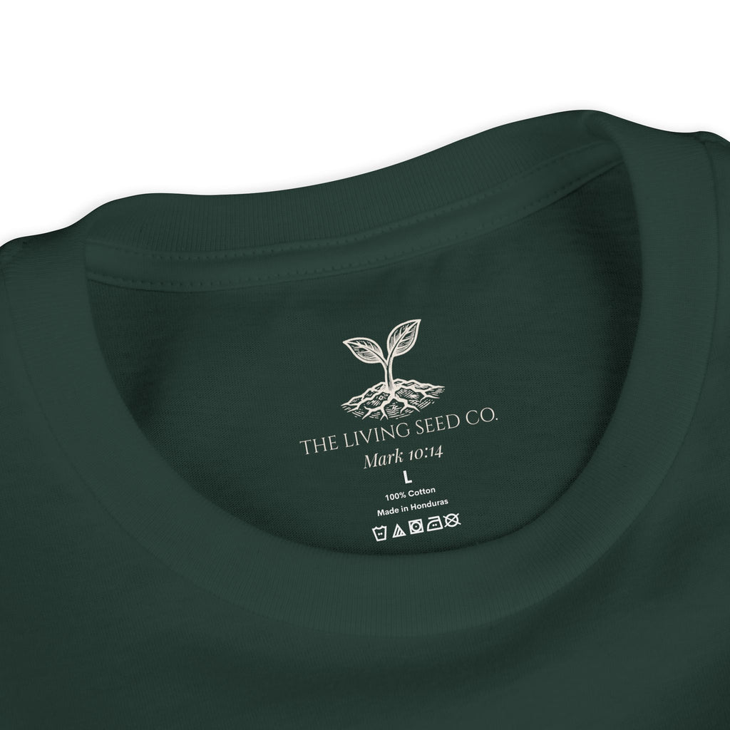 The Original Youth Tee in Forest — neck label closeup — custom printed label featuring The Living Seed Co. logo, Mark 10:14, size, fabric content, and care icons. 100% cotton, made in Honduras.