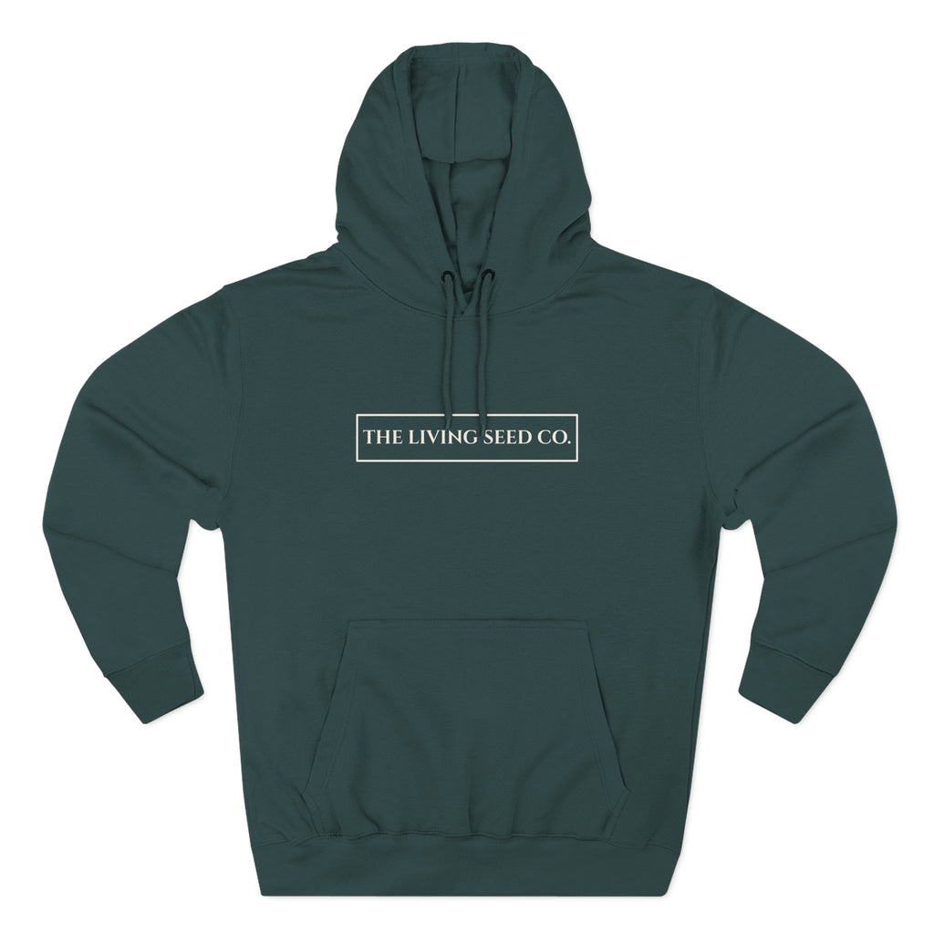 The Original Hoodie (Lane Seven) in Forest — front view flat mockup — forest green pullover hoodie featuring The Living Seed Co. boxed wordmark on chest in parchment ink. Lane Seven LS14001.