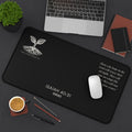 Scripture Series RENEWED Desk Mat in Black 12x22 — lifestyle shot — forest green desk mat on a dark workspace with laptop, coffee, and stationery featuring The Living Seed Co. seedling logo, Isaiah 40:31, RENEWED wordmark, and full Isaiah 40:31 verse in parchment ink.