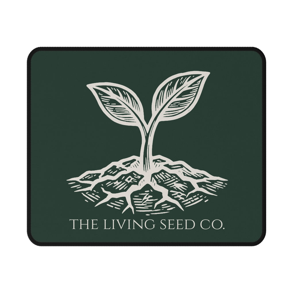 The Original Mouse Pad in Forest Deep — flat mockup — forest green mouse pad featuring The Living Seed Co. etching-style sprouting seed graphic in parchment ink with wordmark below.