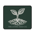 The Original Mouse Pad in Forest Deep — flat mockup — forest green mouse pad featuring The Living Seed Co. etching-style sprouting seed graphic in parchment ink with wordmark below.