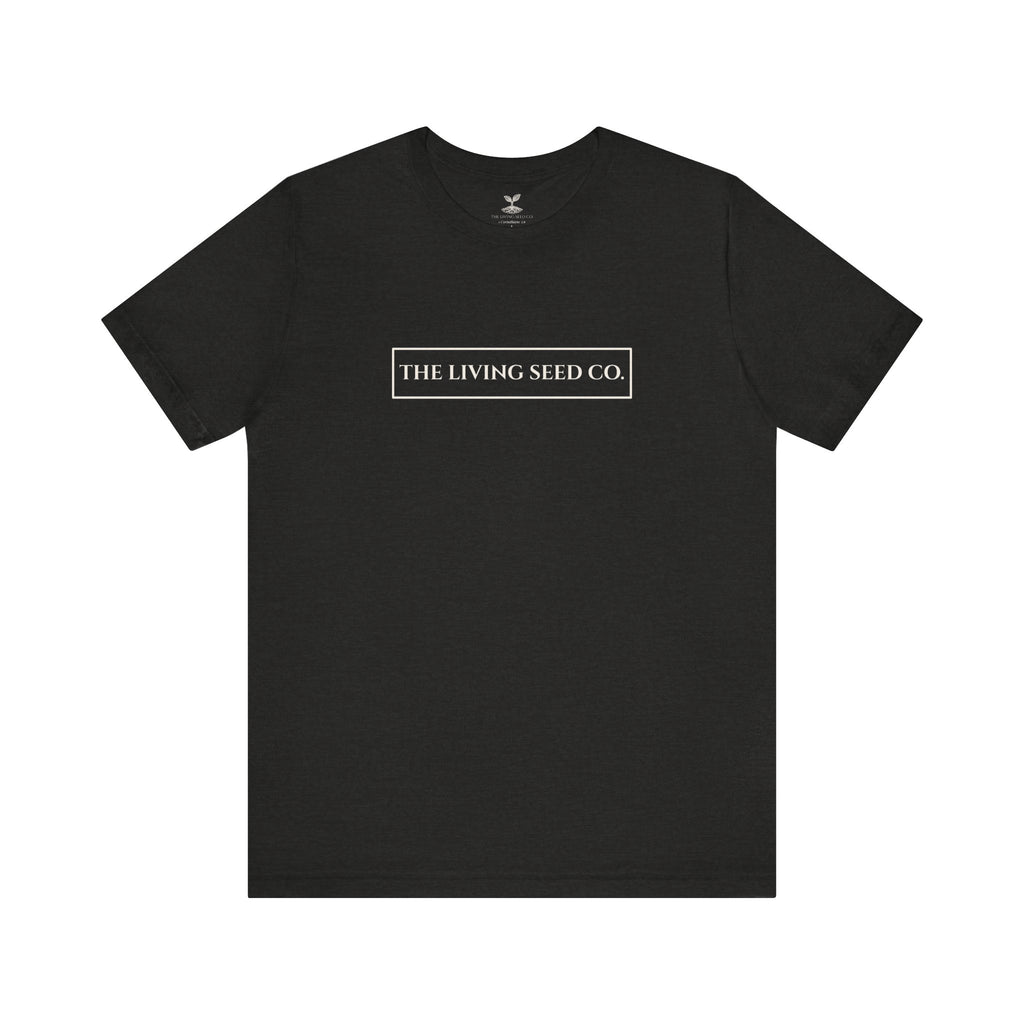 The Original Tee in Black Heather — front view flat mockup — dark grey unisex t-shirt featuring The Living Seed Co. boxed wordmark on chest in parchment ink. Bella+Canvas 3001.
